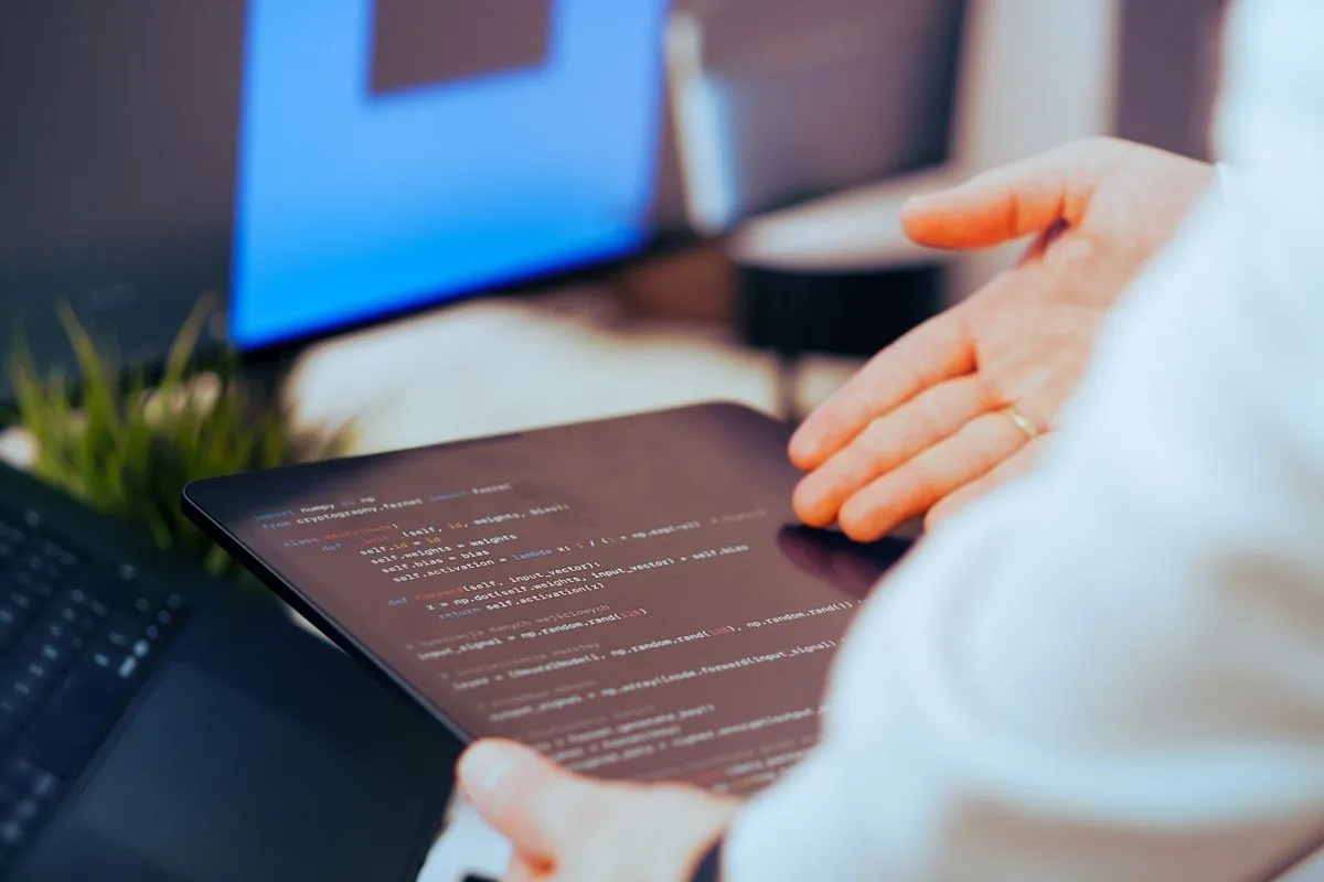 Pessoa revisando código em um tablet, representando a revisão humana do trabalho gerado por IA